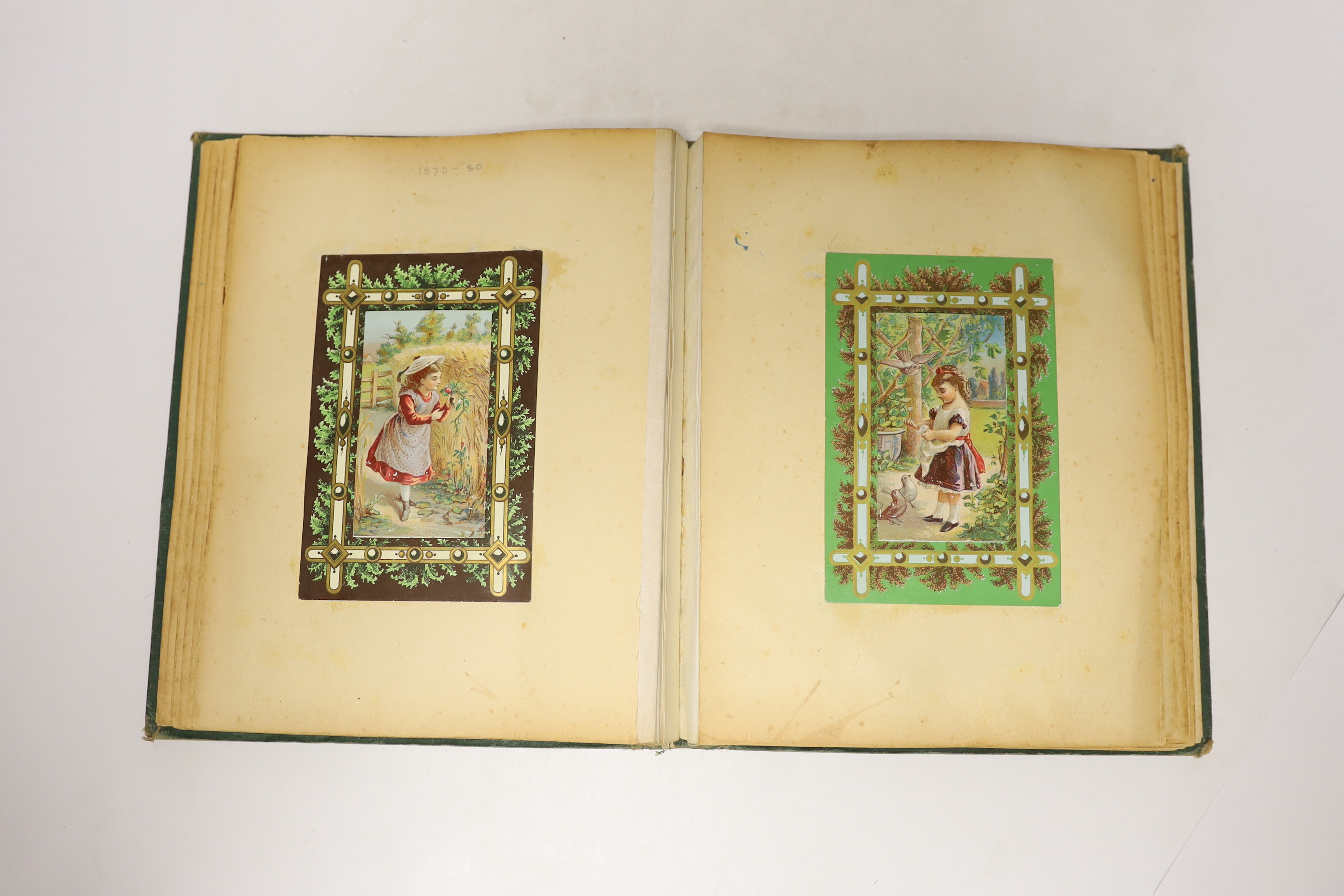 A Victorian scrap album, containing chromolithographic cards and scraps and pressed leaves and two other items